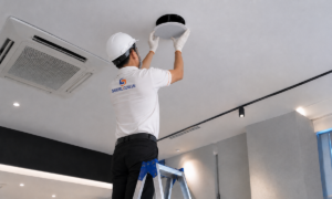 Kỹ thuật viên đang lắp đặt loa âm trần trên trần nhà